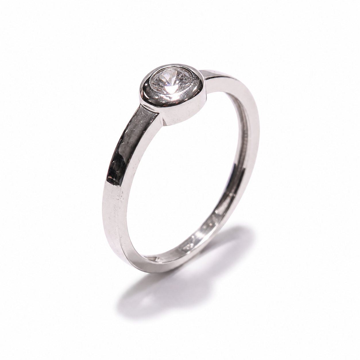 Elegantni zlatni prsten od 14KT zlata ističe se čistom, minimalističkom formom i decentnim cirkonom u središtu. Bijeli ton zlata daje prstenu profinjen i suvremen izgled, dok jednostavan dizajn omogućuje lako kombiniranje s drugim nakitom.