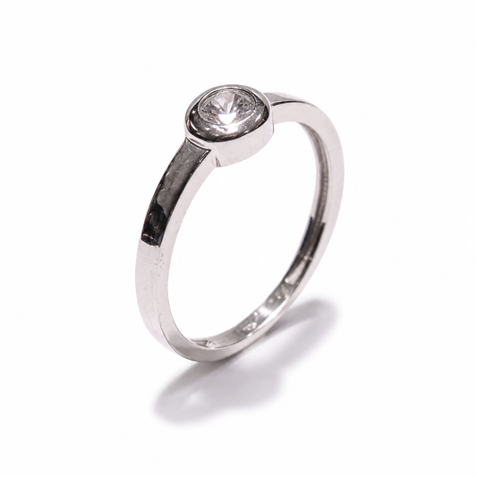 Elegantni zlatni prsten od 14KT zlata ističe se čistom, minimalističkom formom i decentnim cirkonom u središtu. Bijeli ton zlata daje prstenu profinjen i suvremen izgled, dok jednostavan dizajn omogućuje lako kombiniranje s drugim nakitom.